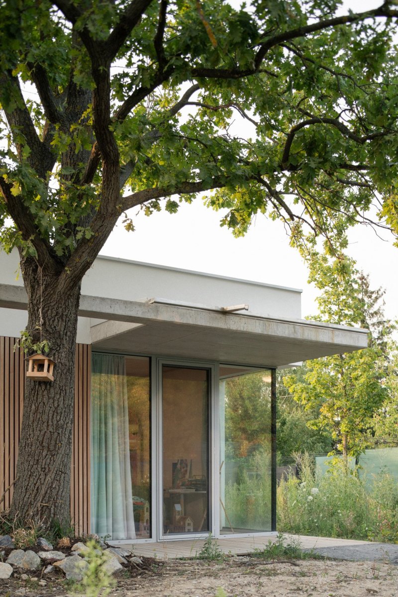 Směrem do zahrady se dům otevírá oky vysokými od podlahy až ke stropu. (Rodinný dům v Záhorských sadech, ČECHVALA ARCHITECTS)