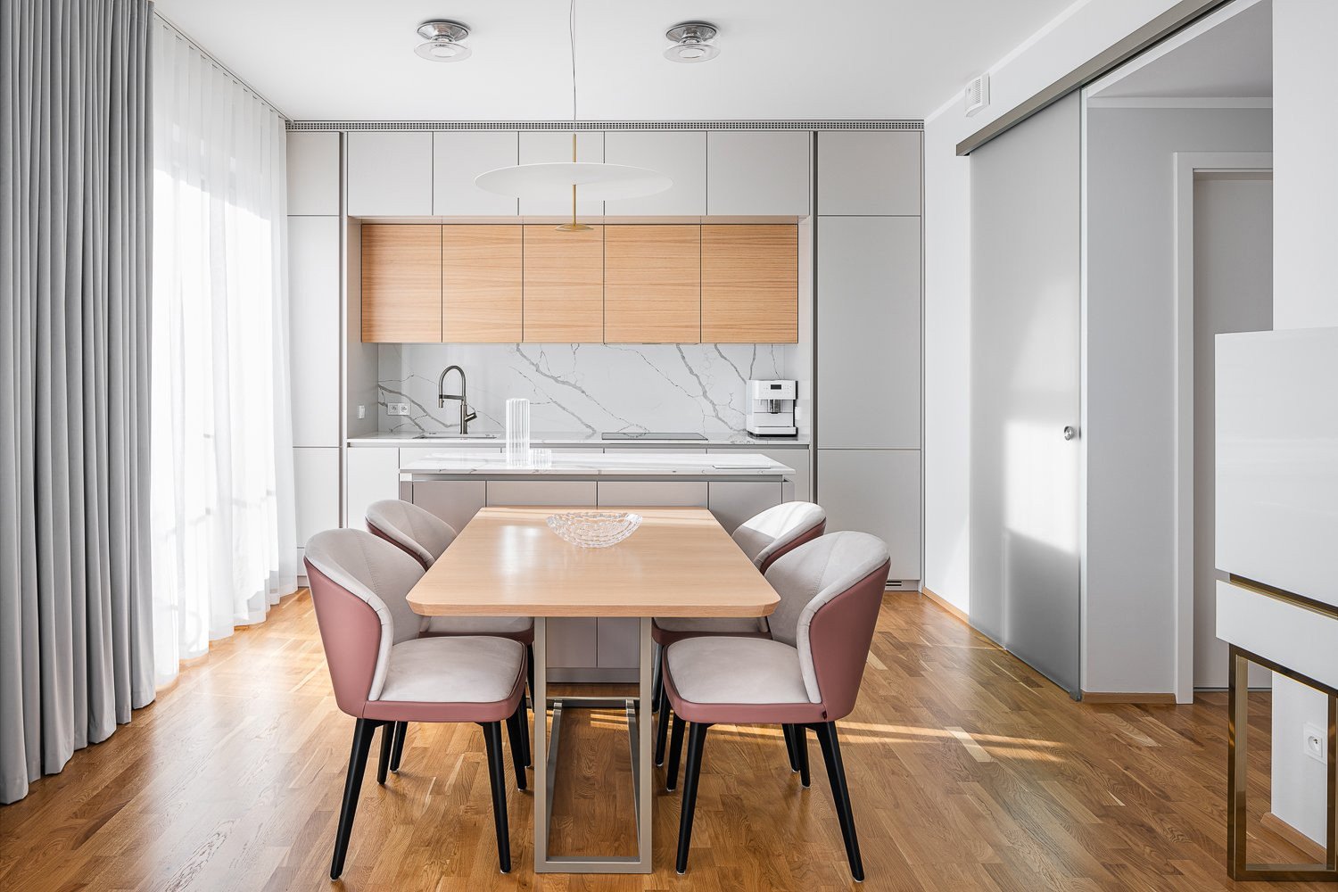 Interiér bytu v Praze-Modřanech od studia Ambience Design - pohled do kuchyně s deskou a obkladem TechniStone Crystal Calacatta Silva