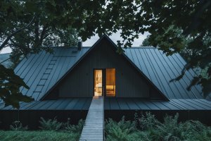 Sedlová střecha a střídmé materiálové řešení reinterpretují tradiční formu krkonošských staveb. (Chalupa ve stráni; Mimosa Architekti)