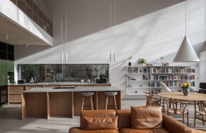 V obývacím pokoji se nachází kuchyně s jídelnou a klidová zóna obývacího pokoje s krbem. (Dům Devín, plusminusarchitects)