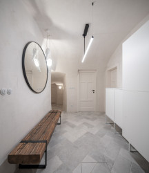 Na podlaze je šedivá dlažba kladená šikmo "na rybinu". (OOOX, Dům ve hradbách)