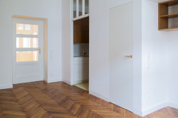 Byt se nachází v domě z počátku 20. století. Na jeho stáří upomínají zrepasované dveře. (Rekonstrukce bytu v Praze, BY architects)