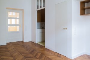 Byt se nachází v domě z počátku 20. století. Na jeho stáří upomínají zrepasované dveře. (Rekonstrukce bytu v Praze, BY architects)