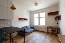 Obytná část je řešena jednoduše, se sedací soupravou a pracovním koutem.  - Rekonstrukce bytu v Praze - Holešovicích, Studio Schwestern.