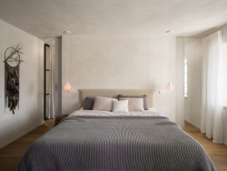 Za zdí, o kterou se opírá čelo postele, se schovává prostorná šatna a vstup do koupelny. 