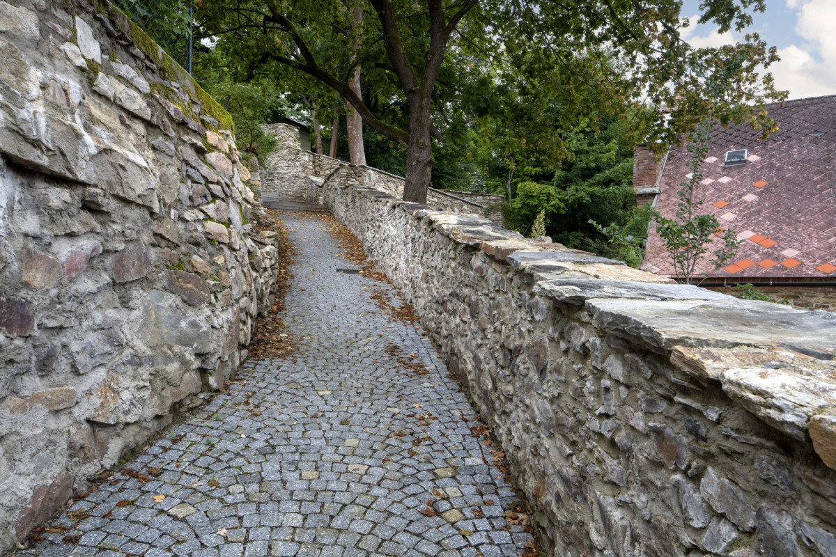 Zlatá stezka – nová dlažba v celém profilu a obnovení kamenné zdi s původními krycími deskami. (Pivovarské terasy; Steiner a Malíková krajinářští architekti, Roman Brychta Architekti)