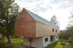 Architekti z 0,5 Studia navrhli dvoupodlažní dřevostavbu, která je vynesena do požadované výšky na dvou betonových podstavách. (Rodinný dům v Řevnicích, 0,5 studio)