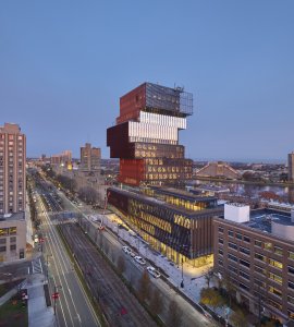 V noci světlo z interiéru prochází skleněnými stěnami a budova září. (Centrum výpočetní a datové vědy Bostonské univerzity, KPMB Architects)