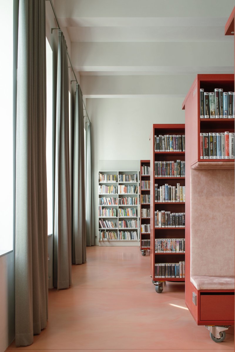Regály mají kolečka, takže se v případě potřeby dají odsunout. (Knihovna v Červeném Kostelci; Papundekl architekti)
