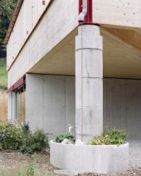 Rodinné komunitní bydlení ve Villy, Madeleine architectes, Studio François Nantermod: Krytý vstup do objektů v rozích podpírají výrazné kulaté betonové sloupy