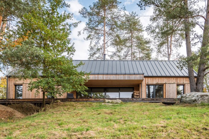 Velký přesah střechy společně s dřevěnými okenicemi zajišťuje skvělé podmínky pro chlazení v létě a efektivní využití slunce během zimy (Dřevostavba v severském stylu, Česká Kanada, arch. návrh Labor 13, dodavatel VESPER HOMES)
