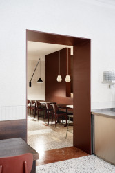 Hnědočervená barví také průchod do zadní místnosti kavárny. (Mezi Srnky, Markéta Bromová Architekti)