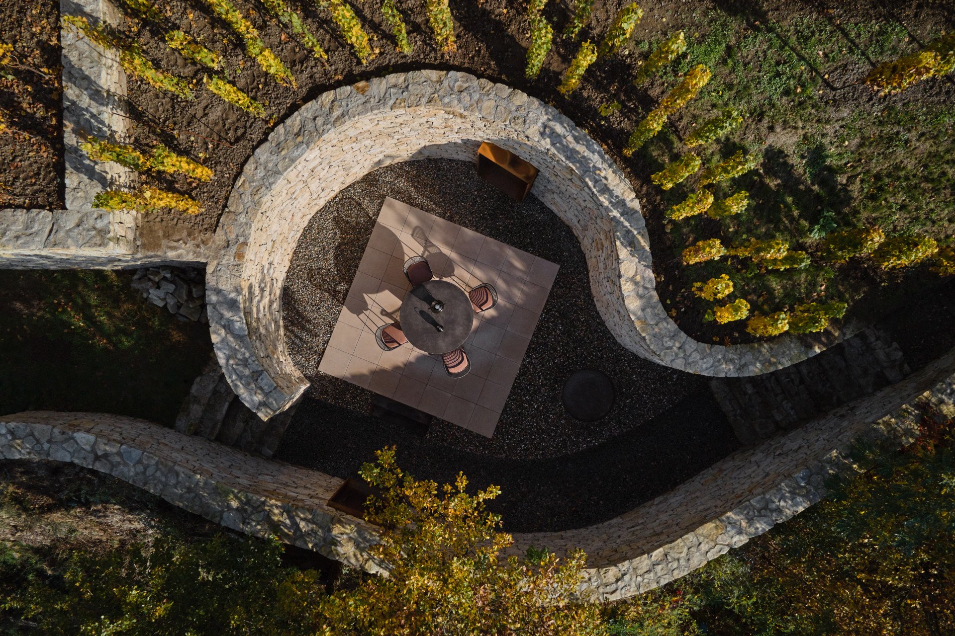 Degustační prostor Fibonacci, Marco Maio Architects: Degustační prostor formuje terasa s posezením zasazená mezi nově vybudované kamenné zdi.