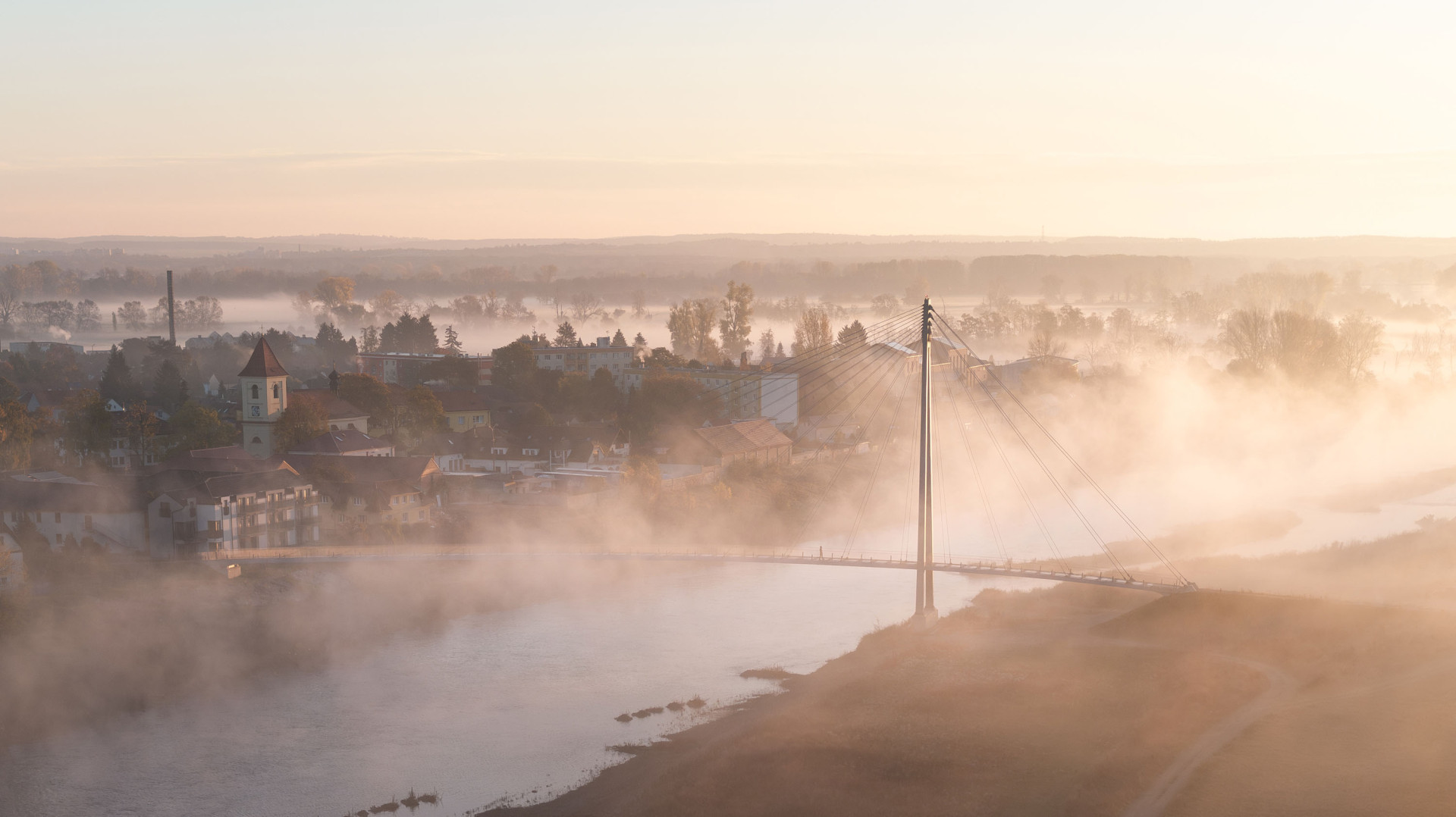 Lávka přes Vltavu v Lužci je tenká linka nad řekou - umožňuje to ultra vysokohodnotný beton UHPC, s nímž pracuje ateliér AI PRAHA. Také mezinárodní porota ocenila subtilní krásu stavby, která ji povyšuje nad běžnou infrastrukturu.