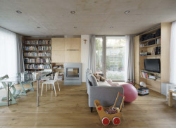 Do hlavního obytného prostoru ústí kuchyň, knihovna, krb a oddělitelné schodiště. (Rodinný dům v Radotíně, Papundekl architekti)