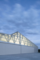 Když se uvnitř rozsvítí, laminát propustí světlo ven. (Hangár ve Zbraslavicích, Studio Raketoplán)