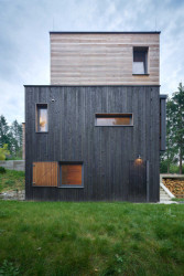 Zajímavé jsou dřevěné okenice, které po otevření fungují jako markýzy. (Chata v Posázaví, Studio Sporadical)