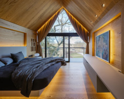 Pohled do ložnice, která se otevírá až do krovu sedlové střechy. (Vila v Trněném Újezdě, de.fakto)