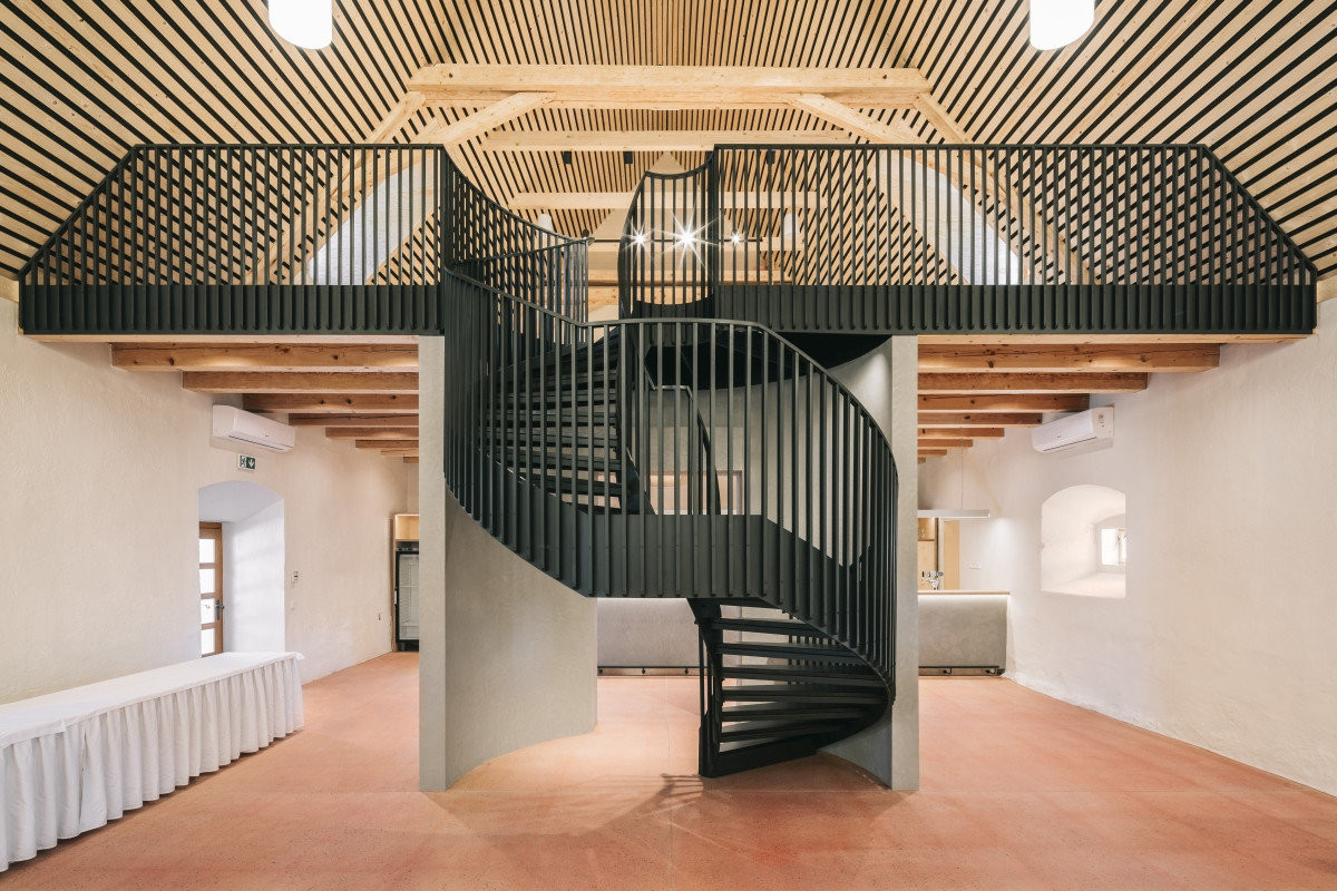 Jednoduchý a minimalistický - takový je interiér špejcharu. Architekti přistupovali k renovaci s pokorou a interiér očišťovali od nepůvodních prvků. Odstraněny byly například zásahy v podobě sloupů a vrátil se otevřený prostor s galerií.