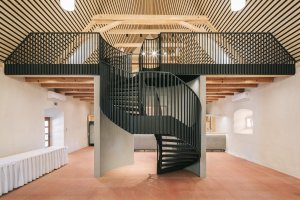 Jednoduchý a minimalistický - takový je interiér špejcharu. Architekti přistupovali k renovaci s pokorou a interiér očišťovali od nepůvodních prvků. Odstraněny byly například zásahy v podobě sloupů a vrátil se otevřený prostor s galerií.