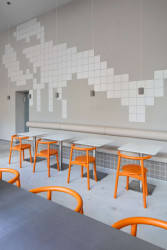 Interiér je postavený na ladění neutrálních tónů a akcentu tmavě oranžové, připomínající barvu raka.  (Rakin Seafood Bar; NEUHÄUSL HUNAL David Neuhäusl, Matěj Hunal)