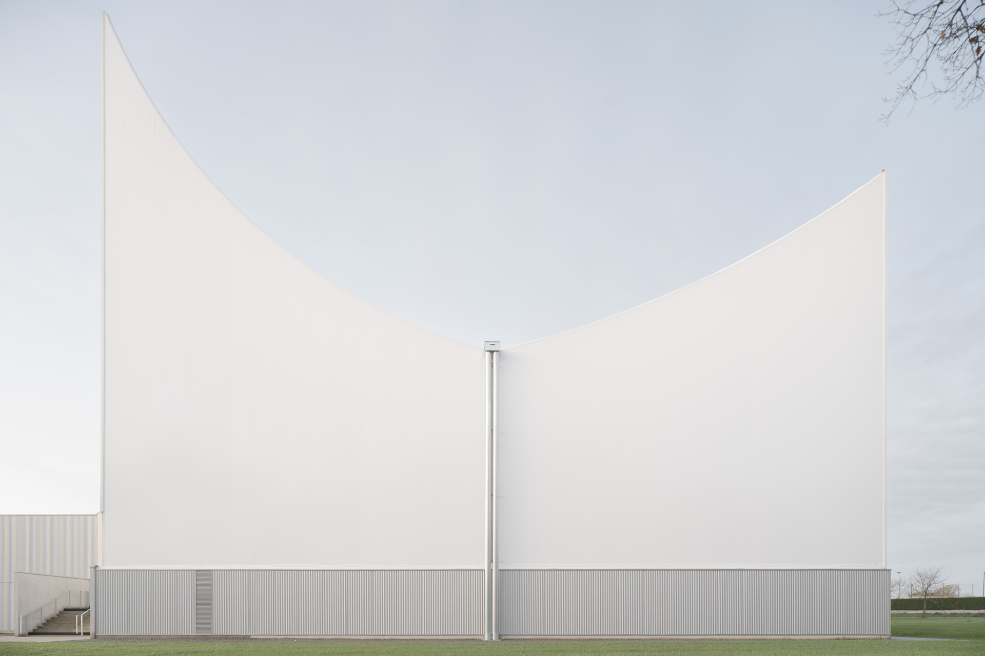 Velká sportovní hala má výrazně modelovanou střechu, její tvar pomáhá ochlazovat interiér. (Sportovní a kulturní centrum Marie-Jose Perec a Josephine Baker v La Bouëxière ve Francii; onze04)