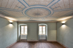 Obnovené interiéry kapucínského kláštera v Žatci s klasicistní výmalbou, která reflektuje bohatství města v době stavby kláštera.