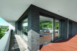 Konstrukce balkónu a střechy jsou konzolové. Spolu s vnějšími žaluziemi přispívají ke stínění a ochraně před oslněním. Viditelné povrchy vnějších profilů okenních a dveřních systémů Schüco byly barevně sjednoceny s tmavým lícovým zdivem.