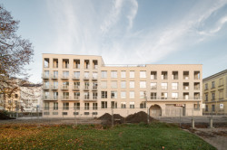 Blok je pomocí různých barev omítky, textury nebo velikosti oken rozdělený do osmi hmot. (Bytový dům Nové Lauby v Ostravě, ateliér znamení čtyř - architekti)