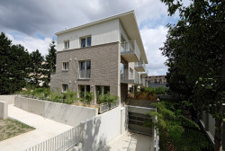 Při straně pozemku vede rampa zpřístupňující garáže. (Bytový dům s nájemními byty na Barrandově, maak, M.A.Tomáš)