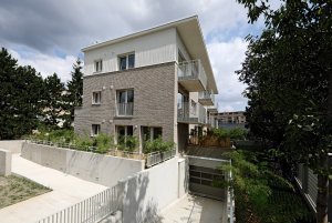 Při straně pozemku vede rampa zpřístupňující garáže. (Bytový dům s nájemními byty na Barrandově, maak, M.A.Tomáš)