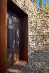 Degustační prostor Fibonacci, Marco Maio Architects: Směrem dolů ze svahu jsou do jedné ze zdí zasazené dveře, který mi se, pokud jsou otevřené, dá prohlédnout k Vltavě.