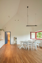 Jižní fasáda je prosklená dlouhým pásovým oknem, které poskytuje výhled do zahrady a okolí. (Rodinný dům v Řevnicích, 0,5 studio)