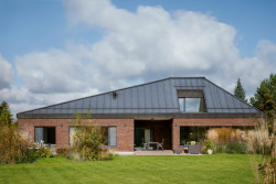 Dům je přízemní, propojený se zahradou. Výhled do dálky si však obyvatelé přece jen užijí.