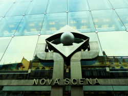 Logo Nové scény Národního divadla u vstupních dveří.