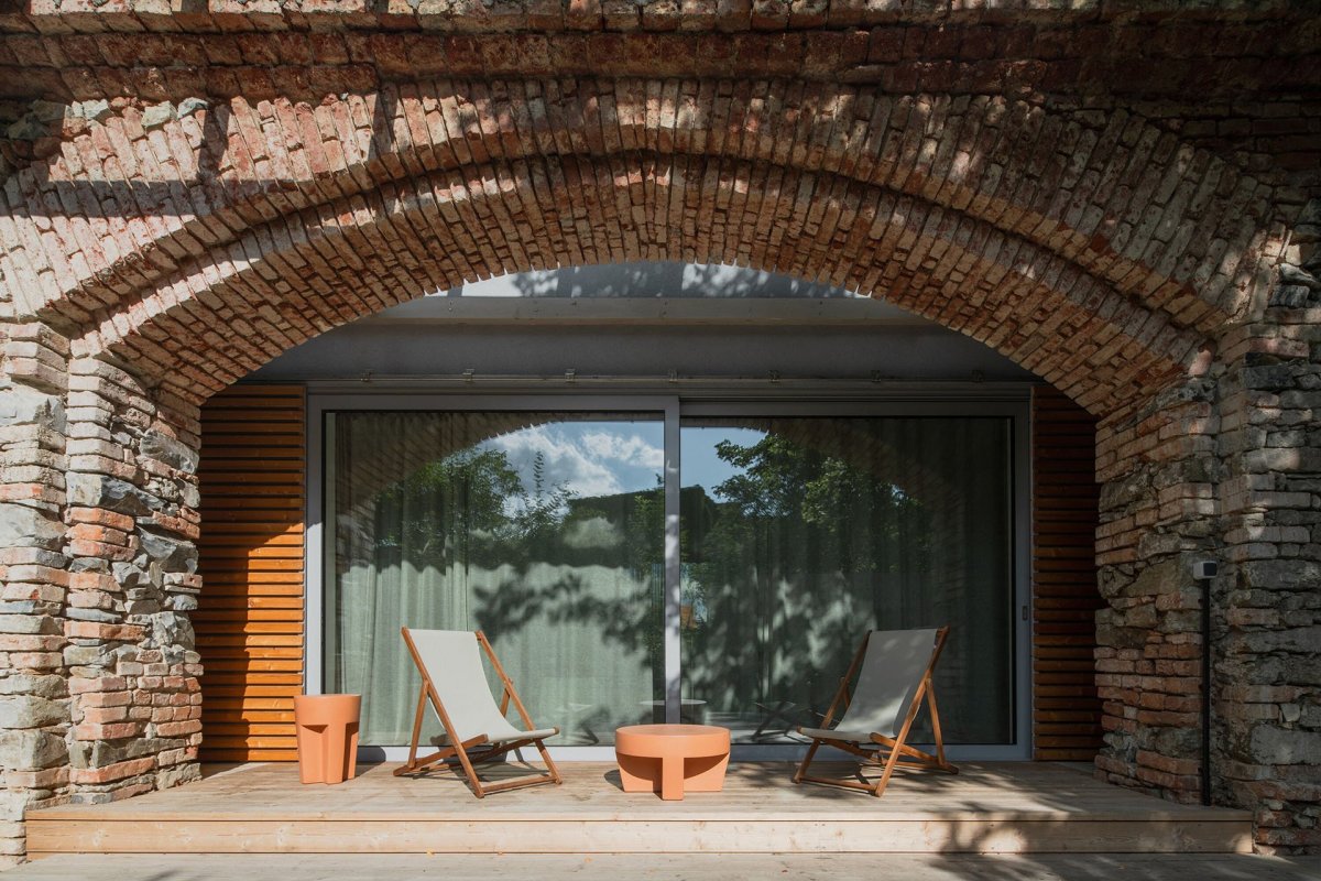 Z obývacího pokoje pokračuje dřevěná terasa do zahrady. (Zapomenutá stodola, Karnet architekti)