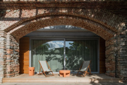 Z obývacího pokoje pokračuje dřevěná terasa do zahrady. (Zapomenutá stodola, Karnet architekti)