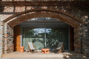 Z obývacího pokoje pokračuje dřevěná terasa do zahrady. (Zapomenutá stodola, Karnet architekti)