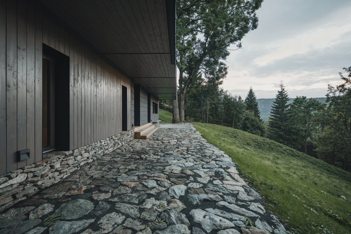 Kamenná podezdívka a přírodní materiály navazují na tradiční charakter krkonošských horských staveb. (Chalupa ve stráni; Mimosa Architekti)