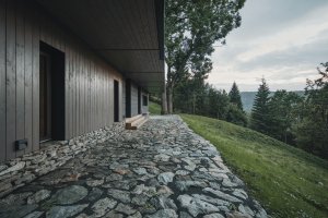 Kamenná podezdívka a přírodní materiály navazují na tradiční charakter krkonošských horských staveb. (Chalupa ve stráni; Mimosa Architekti)