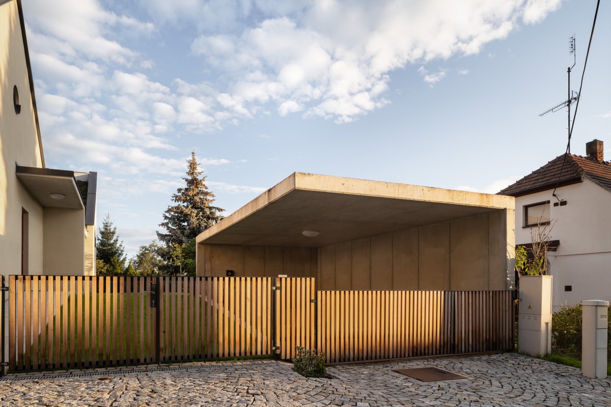 V přední části pozemku je kryté stání pro auto. Má vykonzolovanou betonovou desku a jednou stavbu poroste zeleň. (Rodinný dům v Křenovicích, ika.architekti)