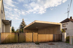 V přední části pozemku je kryté stání pro auto. Má vykonzolovanou betonovou desku a jednou stavbu poroste zeleň. (Rodinný dům v Křenovicích, ika.architekti)