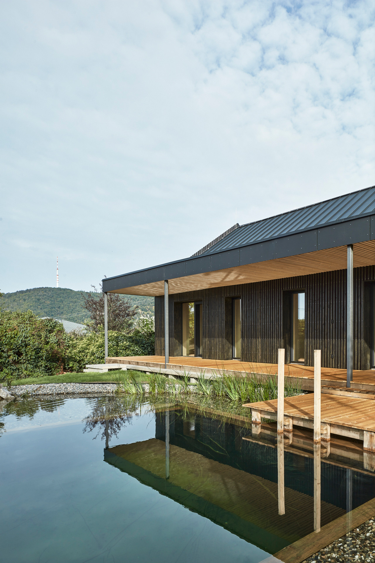 Terasa sousedí s koupacím jezírkem. (Dům ve Vraném nad Vltavou, 0,5 Studio)