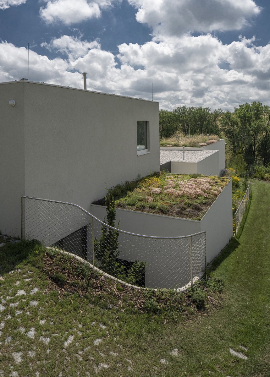 Opěrná zeď a k ní přiléhající atrium. (A69 architekti, rodinný dům ve Slivenci)