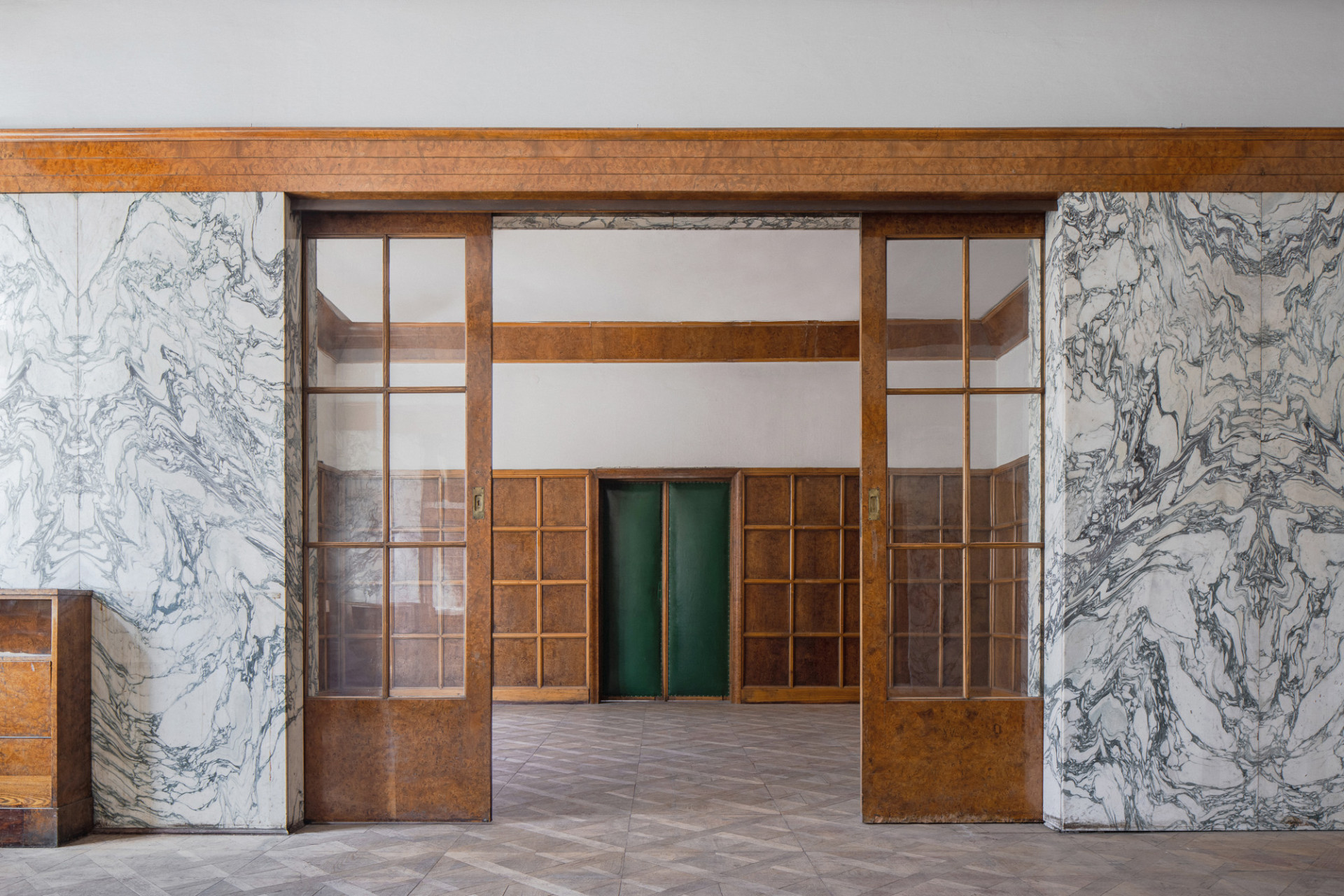 Dámský pokoj, který rovněž plnil úlohu hudebního salonku. Dominantou je světlý mramorový obklad stěn s tmavým prokreslením skládaný do pravidelně se opakujícího ornamentu.  (Loosovy interiéry na Klatovské 19)