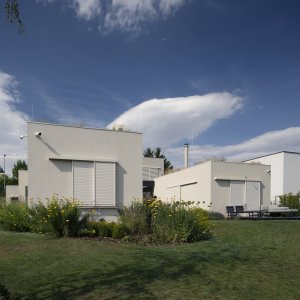 Vstup a garáž jsou v úrovni ulice, zbytek domu o patro níž. (A69 architekti, rodinný dům ve Slivenci)