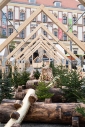 Uvnitř je instalace se zlatavých klád zvaná Zlaté dřevo. (Consequence forma architects, dětská vesnička v Brně)