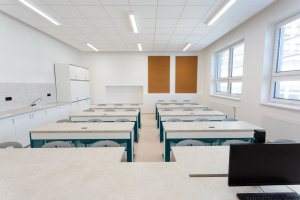 Nástavba základní školy Vidče vyřešila nedostatek prostor pro výuku. Pracuje s kontrastem mezi tmavou současnou vrstvou a původní světlou fasádou z 80. let.