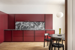 Ústředním prvkem interiéru je vínově laděná kuchyňská sestava s výraznou kamennou kresbou. (Byt Mariánska v Bratislavě, NOIZ architekti)