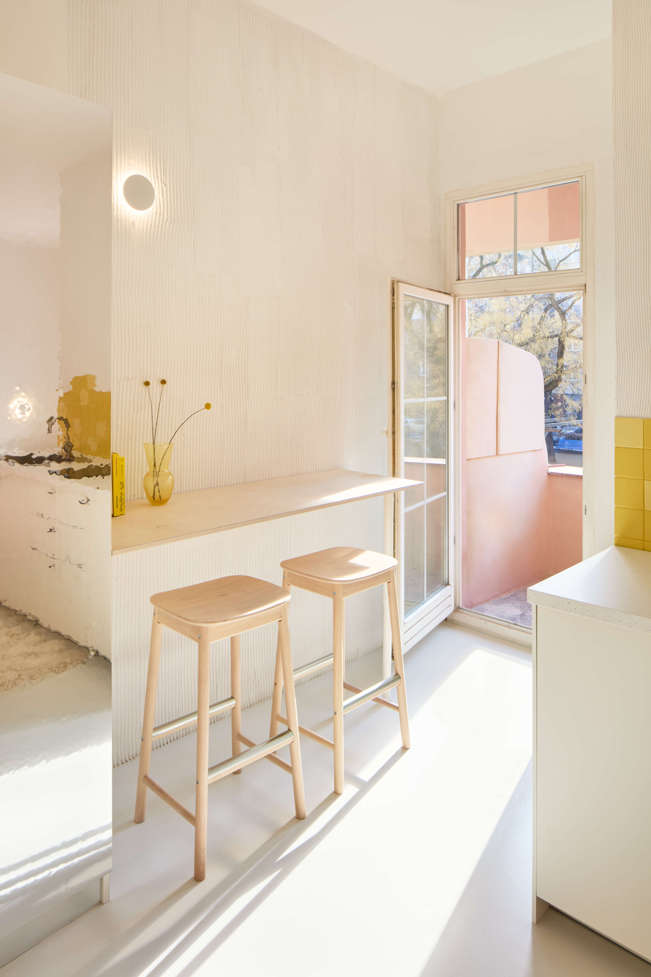 Na originálně zpracovaný botník plynule navazuje barový stůl. (Byt pro malířku v Praze-Holešovicích od Plus One Architects)